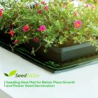 A heat mat with small plants and pink flowers, labeled as a seedfactor product for enhancing plant growth and seed germination.
